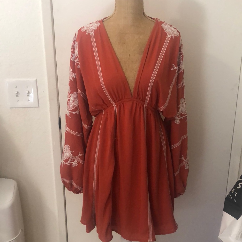 Beautiful boho dress with floral embroidery. Baby doll style low cut front.